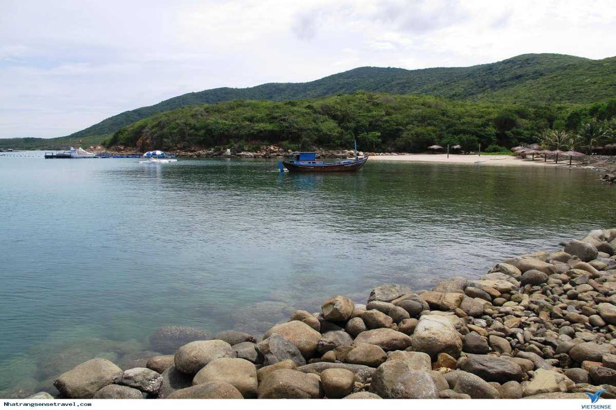 Bai San Beach pebble shoreline and clear waters Pebble-covered shore at Bai San Beach with calm and clear blue waters in Nha Trang