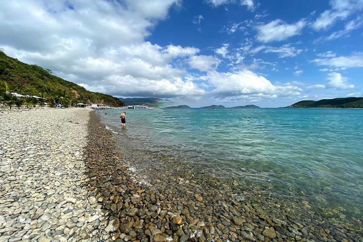 Bai San Beach sandy bay and lush vegetation Sandy bay with green plants and rocky cliffs overlooking Bai San Beach in Nha Trang