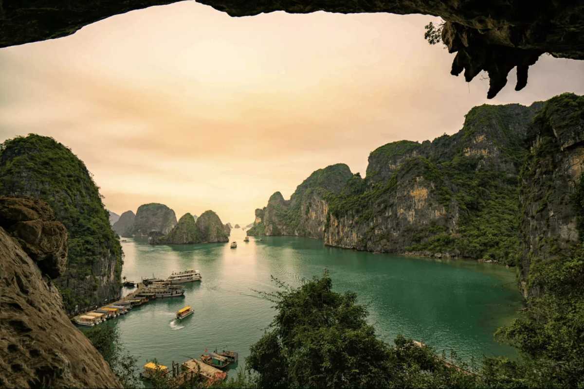 Bai Tu Long Bay Vietnam limestone cave entrance Limestone cave entrance overlooking Bai Tu Long Bay Vietnam’s turquoise waters and towering cliffs.