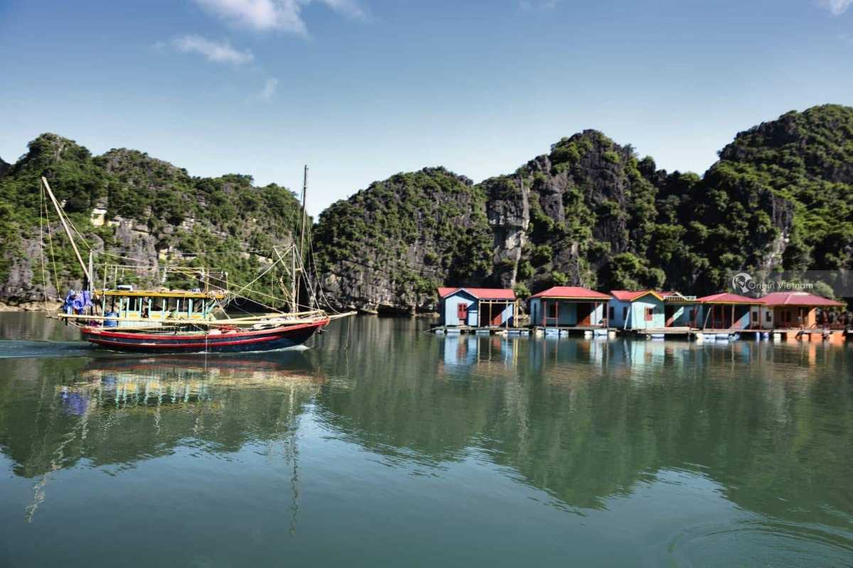 Bai Tu Long Bay luxury cruise boat sailing Luxury cruise boat sails through emerald waters of Bai Tu Long Bay Vietnam amid limestone islands.