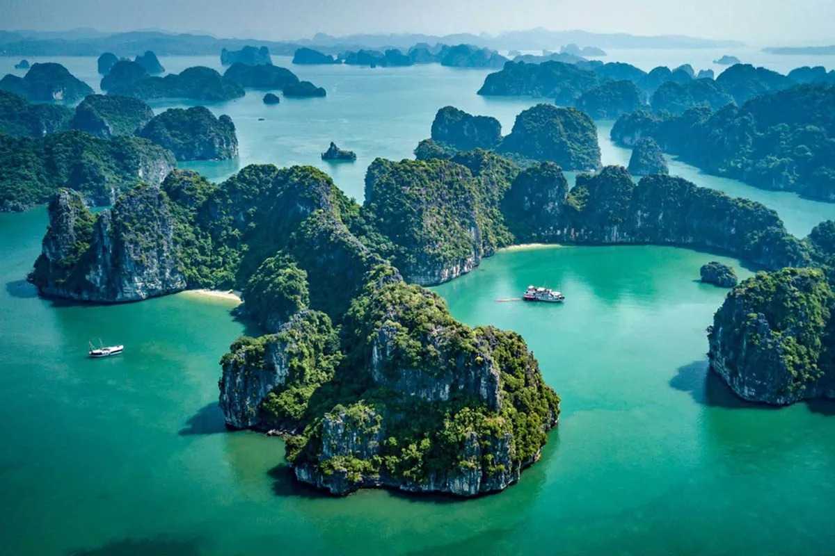 Bai Tu Long Bay serene bay with boats Serene bay waters in Bai Tu Long Bay Vietnam dotted with boats and surrounded by towering limestone formations.