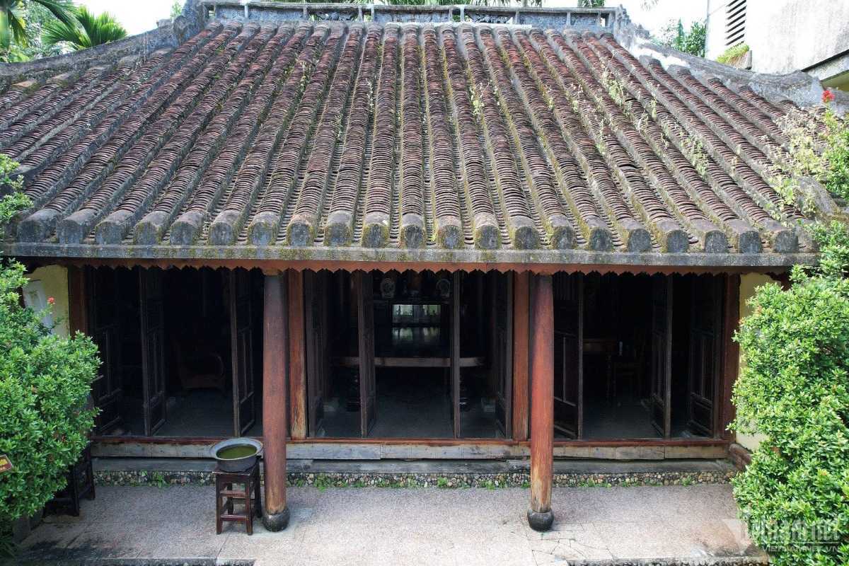 Front facade of wooden ancestral home Classic wooden home with clay tile roofing and large wooden pillars in Phu Vinh Ancient Village
