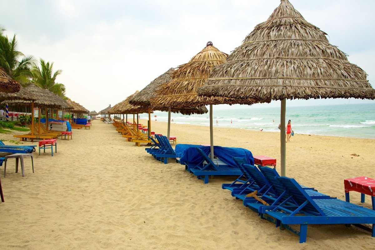 Beachfront Chairs and Umbrellas at Cua Dai Beach Colorful beach chairs and umbrellas aligned on Cua Dai Beach with gentle waves in the background