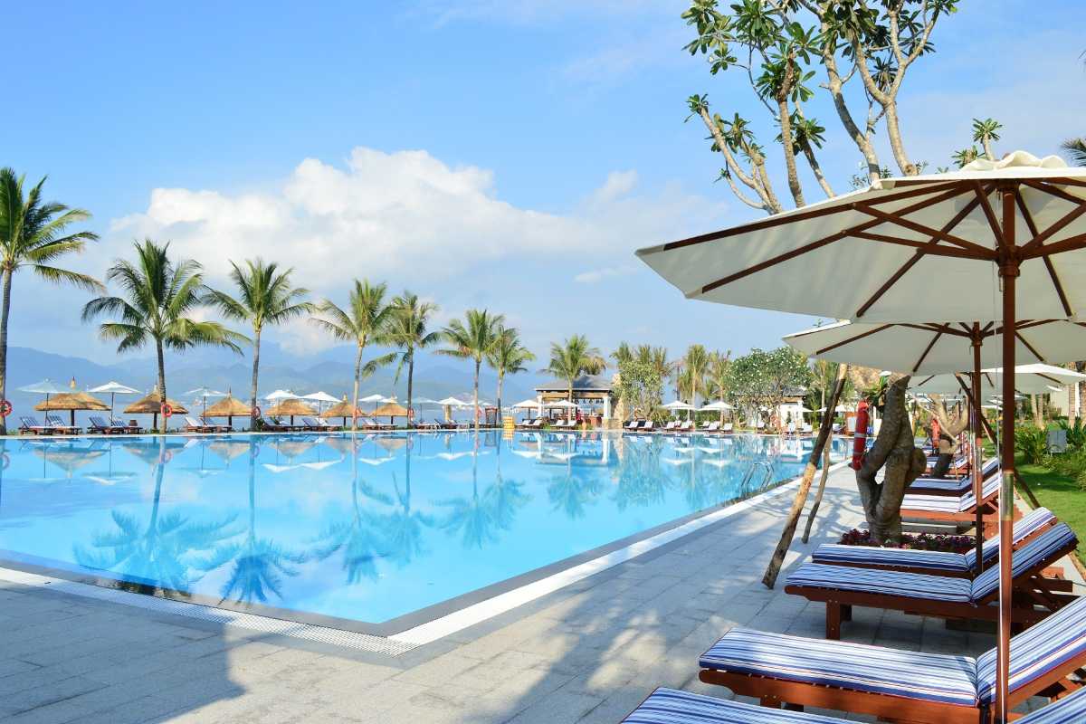 Beachfront pool at Nha Trang Bay resort Beachfront pool area at a resort in Nha Trang Bay with sun loungers and umbrellas