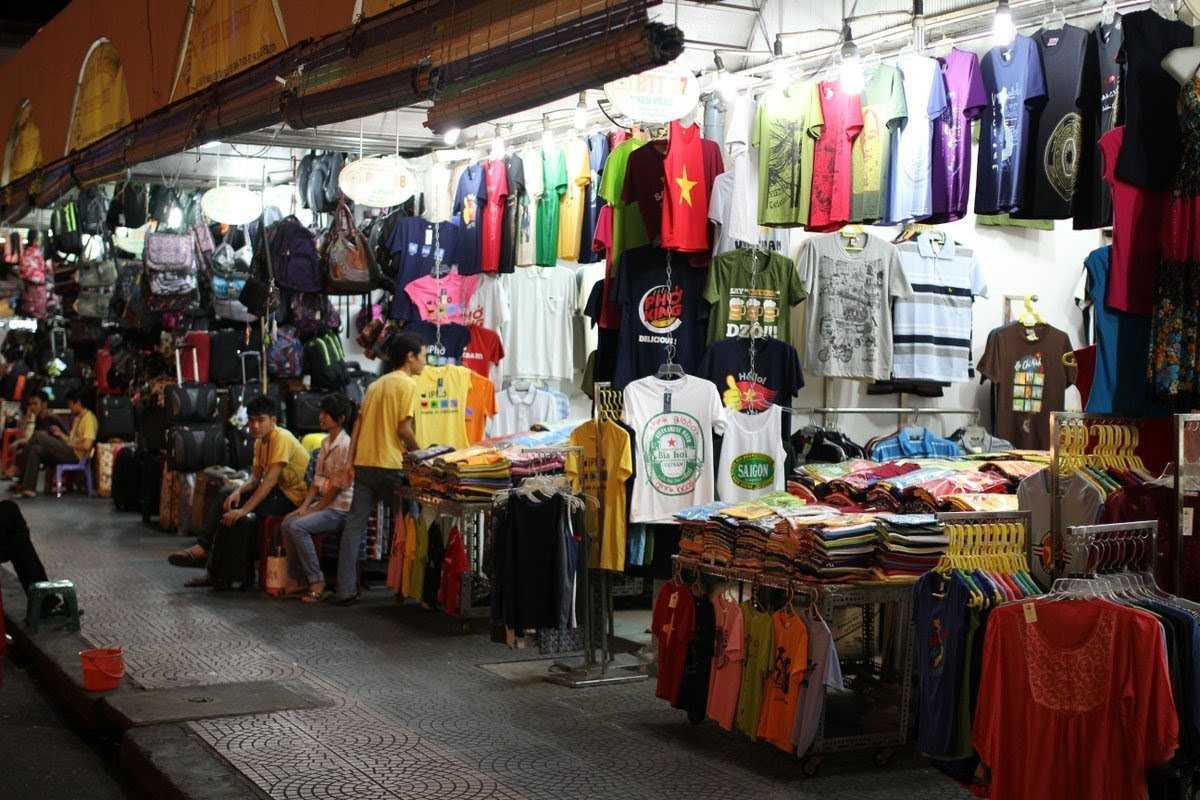 Ben Thanh Market interior busy shopping scene Interior view of Ben Thanh Market bustling with shoppers and rows of diverse merchandise