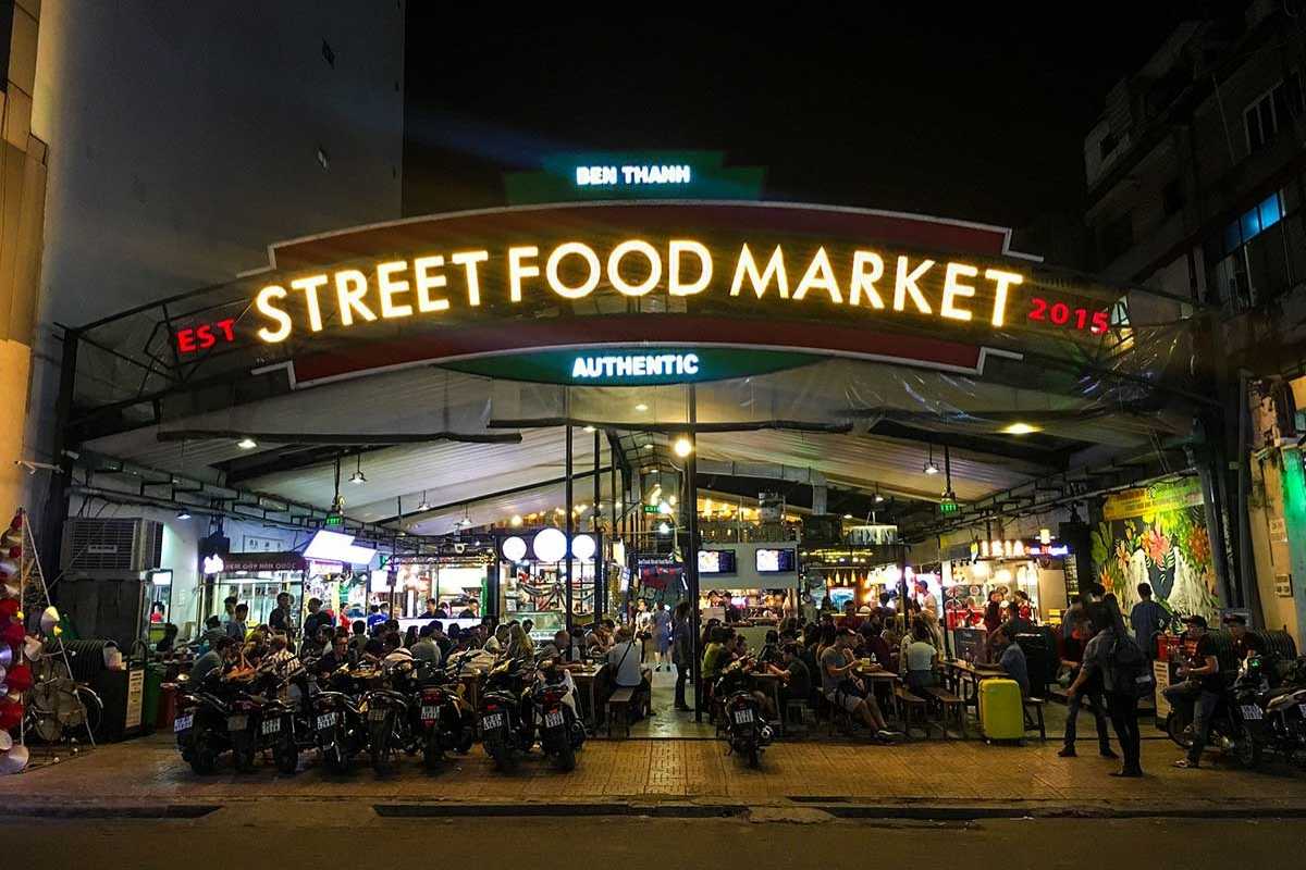 Ben Thanh Market street food market entrance sign at night Entrance sign to Ben Thanh Market street food area illuminated at night with crowds