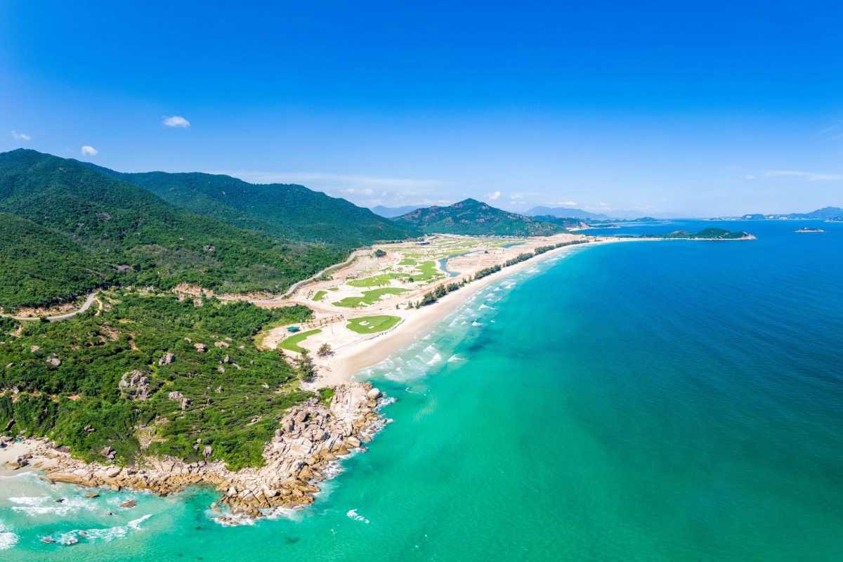 Aerial View of Binh Tien Beach and Surrounding Landscape Aerial shot showcasing Binh Tien Beach’s white sandy beach and surrounding green hills