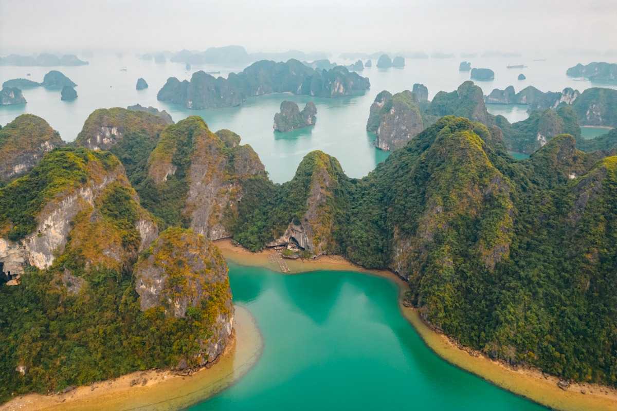 Bo Nau Cave Halong Bay tranquil boat ride A tranquil boat ride on the emerald waters near Bo Nau Cave Halong Bay, surrounded by lush green mountains.