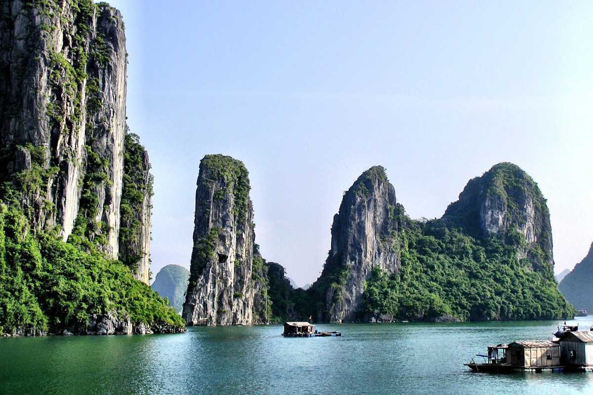 Bo Nau Cave Halong Bay clear waters and towering limestone peaks A picturesque scene from Bo Nau Cave in Halong Bay, with clear waters and towering limestone formations.