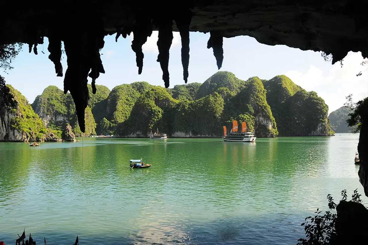 Bo Nau Cave Halong Bay scenic limestone cliffs and boats Scenic Bo Nau Cave Halong Bay with traditional boats floating near limestone cliffs, offering a calm escape.