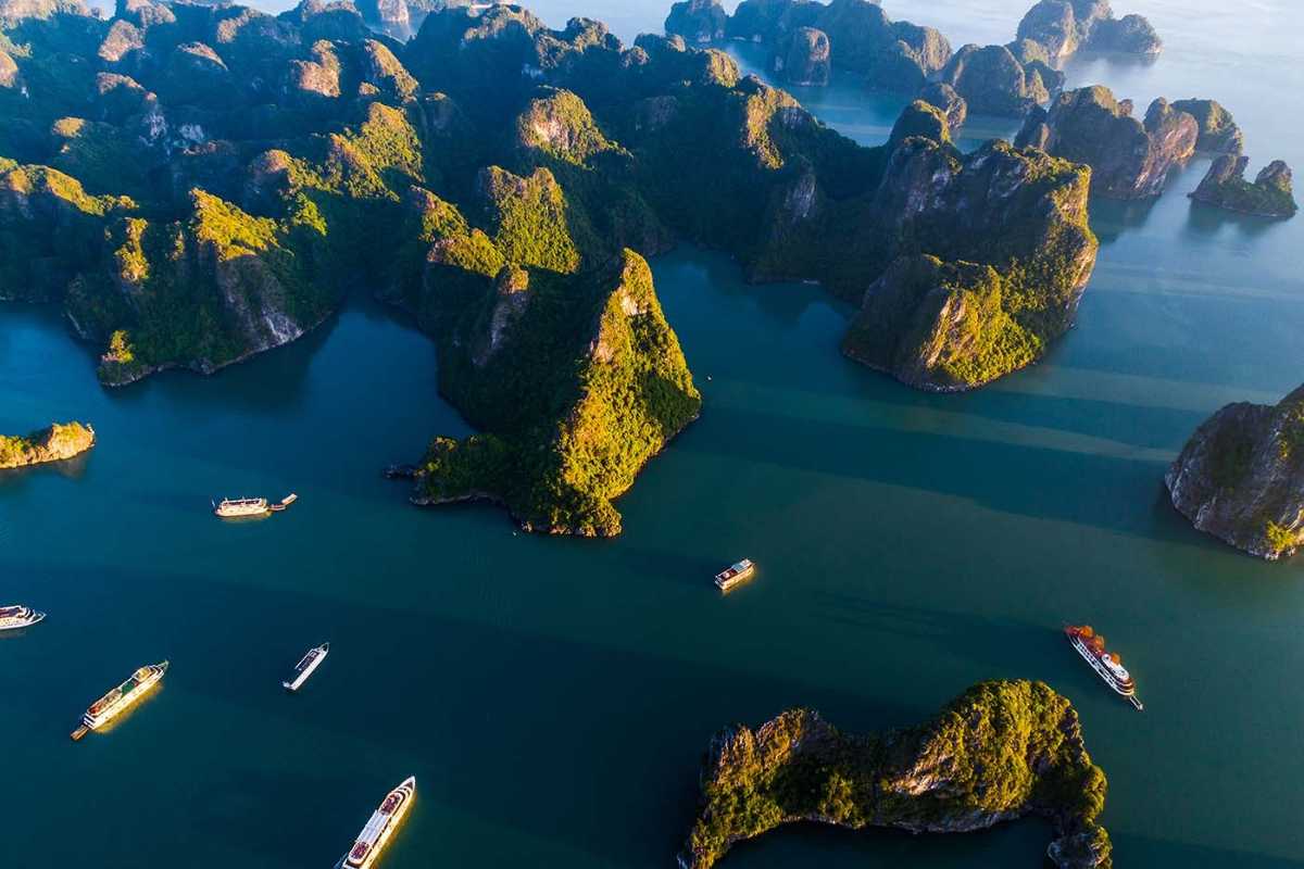 Bo Nau Cave Halong Bay panoramic aerial view of floating boats A panoramic view from Bo Nau Cave in Halong Bay, showcasing floating boats amidst lush karst peaks.