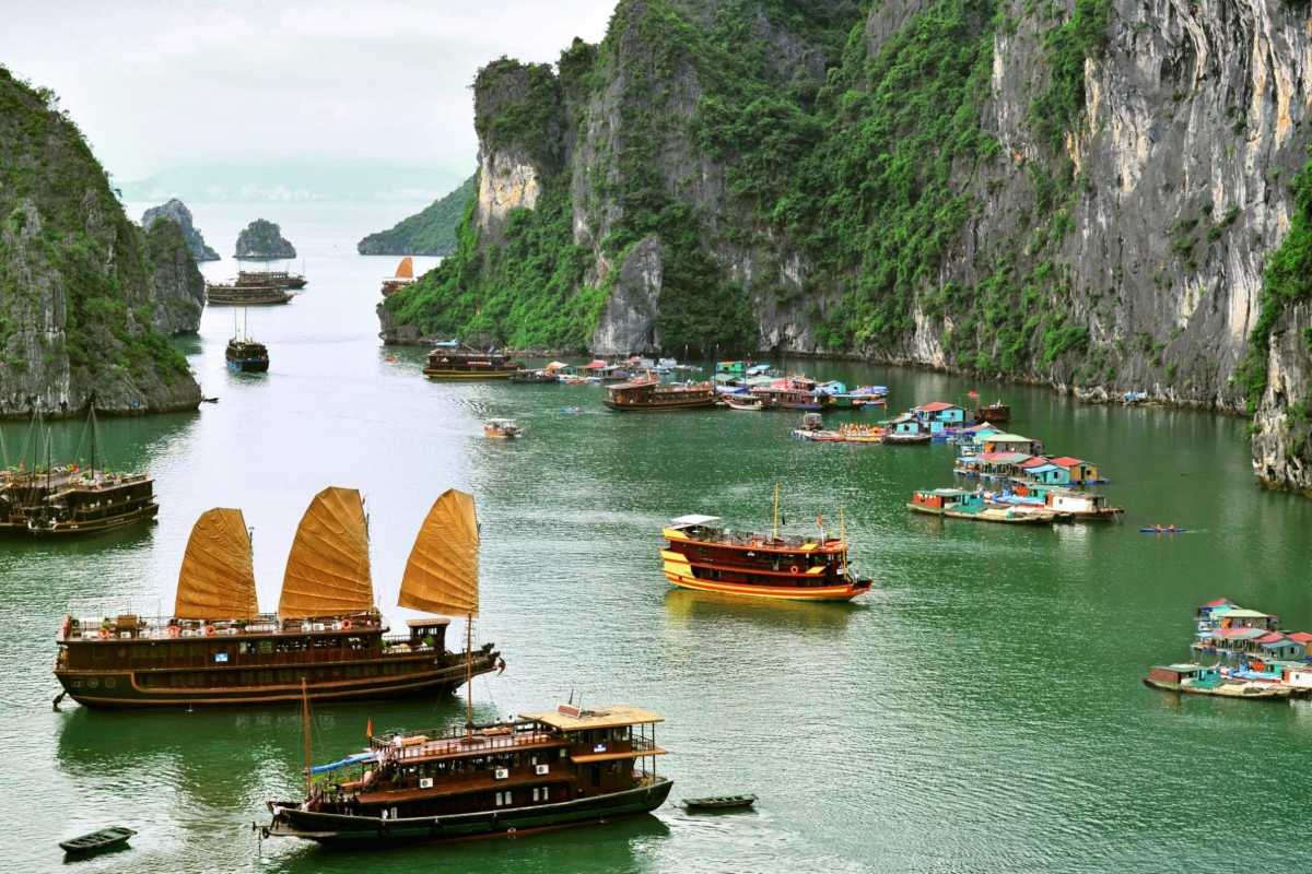 Bo Nau Cave Halong Bay picturesque boat journey A picturesque boat journey through Bo Nau Cave Halong Bay, with towering peaks and clear waters surrounding.