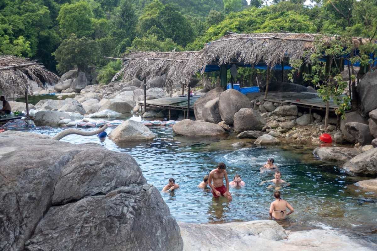 Elephant Springs boulder pools and bamboo shelters Visitors enjoying shallow pools and rock formations beside bamboo huts at Elephant Springs in Hue