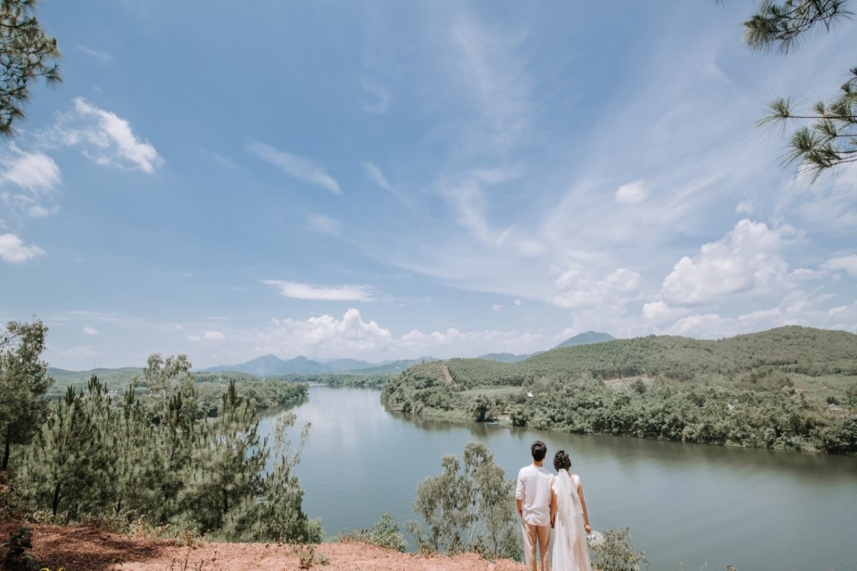 A couple gazes at the breathtaking view of the Perfume River from Vong Canh Hill in Hue, Vietnam.