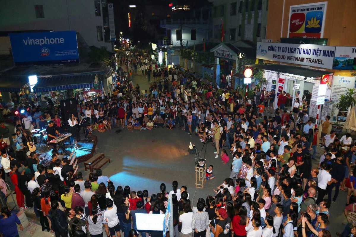 Busy Nightlife Street Scene in Hue City Overhead view of a busy nightlife street filled with pedestrians and motorbikes at night in Hue
