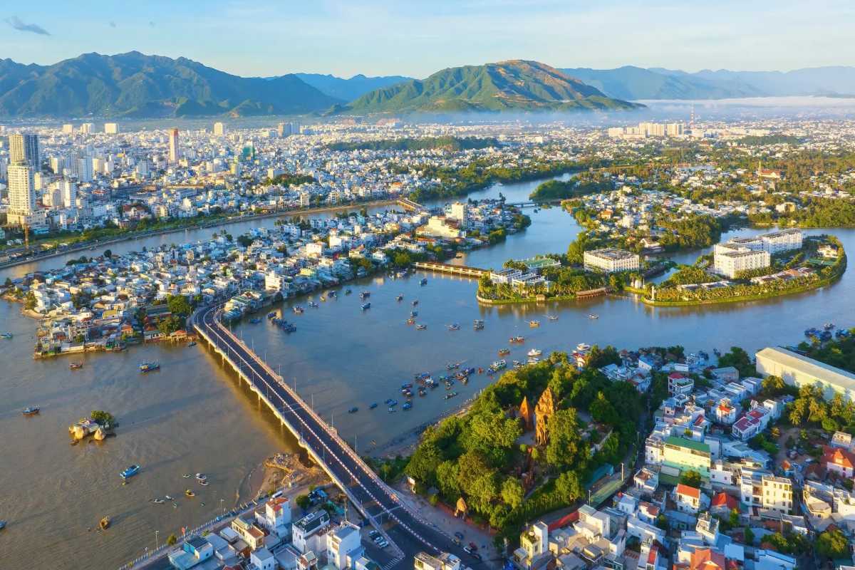 Cai River Estuary and City Island View An elevated view of the Cai River’s estuary with a city island, bridges, and Po Nagar Cham Towers visible in Nha Trang.