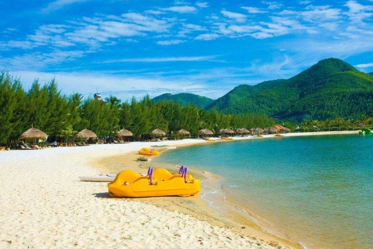 Camping on sandy beach at Thi Island Camping tents pitched on a sandy beach with green hills in the background on Thi Island