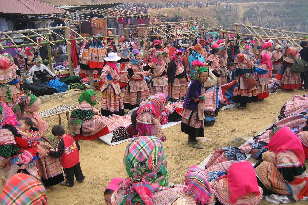 Can Cau Market Lao Cai ethnic Flower Hmong traders gathering Flower Hmong women in traditional dress crowd Can Cau Market to sell handmade textiles and local products