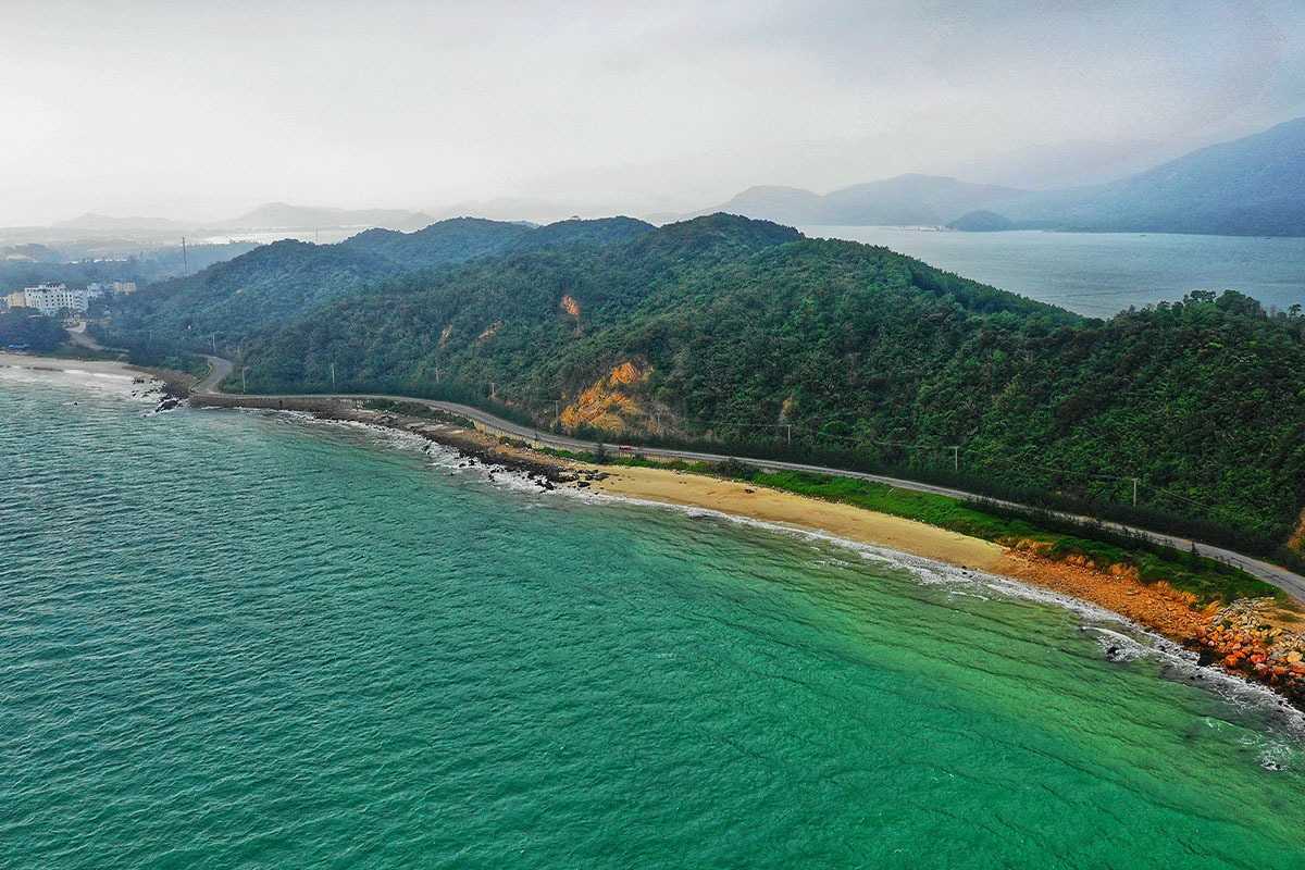 Coastal Road Near Cap La Island Bai Tu Long Bay Coastal road along the shore near Cap La Island in Bai Tu Long Bay with forested hills and turquoise sea