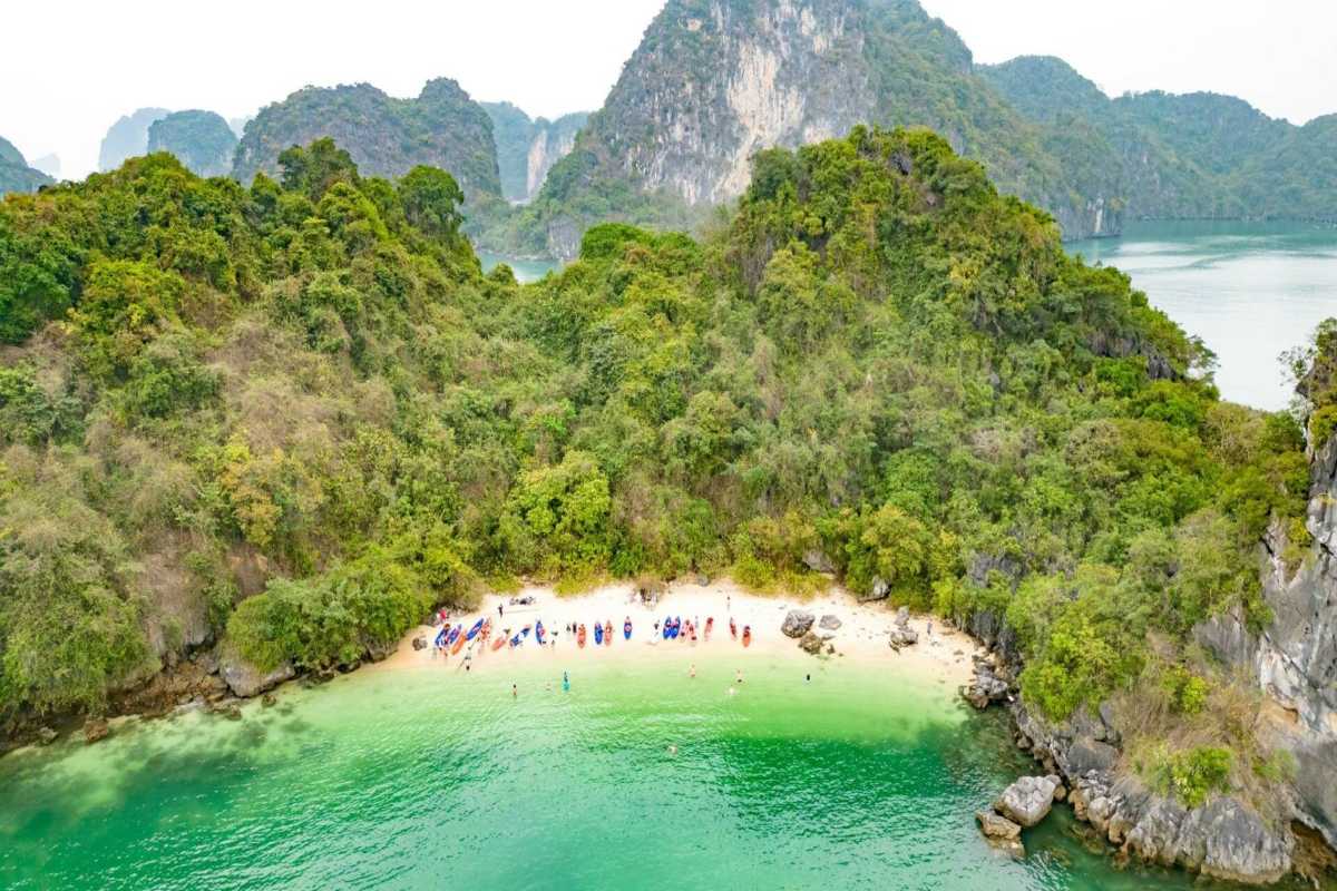 Cap La Island Bai Tu Long Bay Hidden Cove and Kayaking Hidden cove at Cap La Island in Bai Tu Long Bay with kayaks lined up on the shore and clear turquoise water