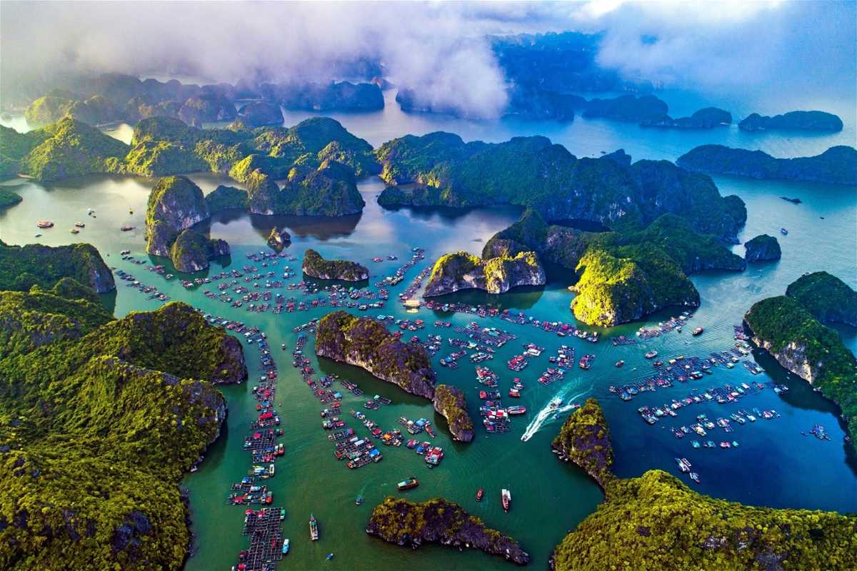 Cap La Island Bai Tu Long Bay panoramic bay view Panoramic view of boats sailing in the calm bay of Cap La Island in Bai Tu Long Bay surrounded by karst cliffs