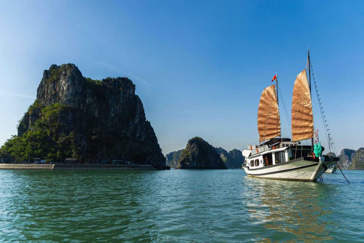 Cap La Island Bai Tu Long Bay traditional boat Cap La Island in Bai Tu Long Bay with traditional Vietnamese boat sailing among limestone karsts and calm waters