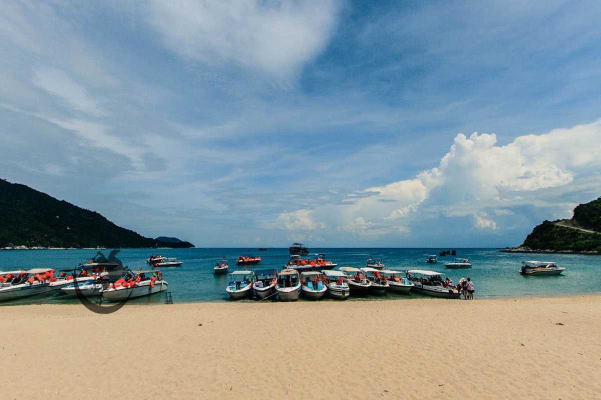 Bustling Boat Dock at Cham Islands Beach Busy boat dock with multiple boats and visitors on the sandy beach at Cham Islands