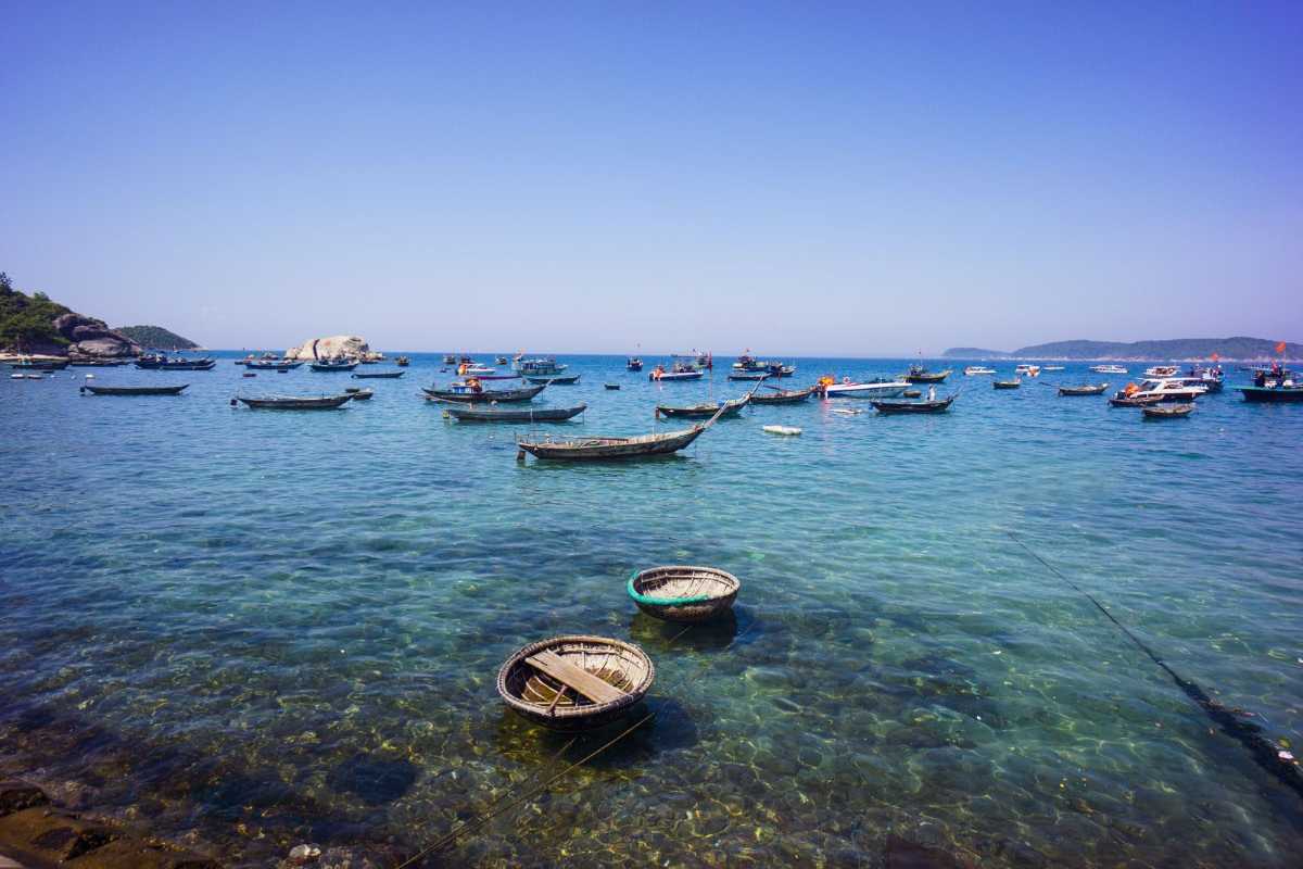 Clear Waters and Coastal Scenery of Cham Islands Crystal-clear turquoise waters and lush green hills along the coastline of Cham Islands