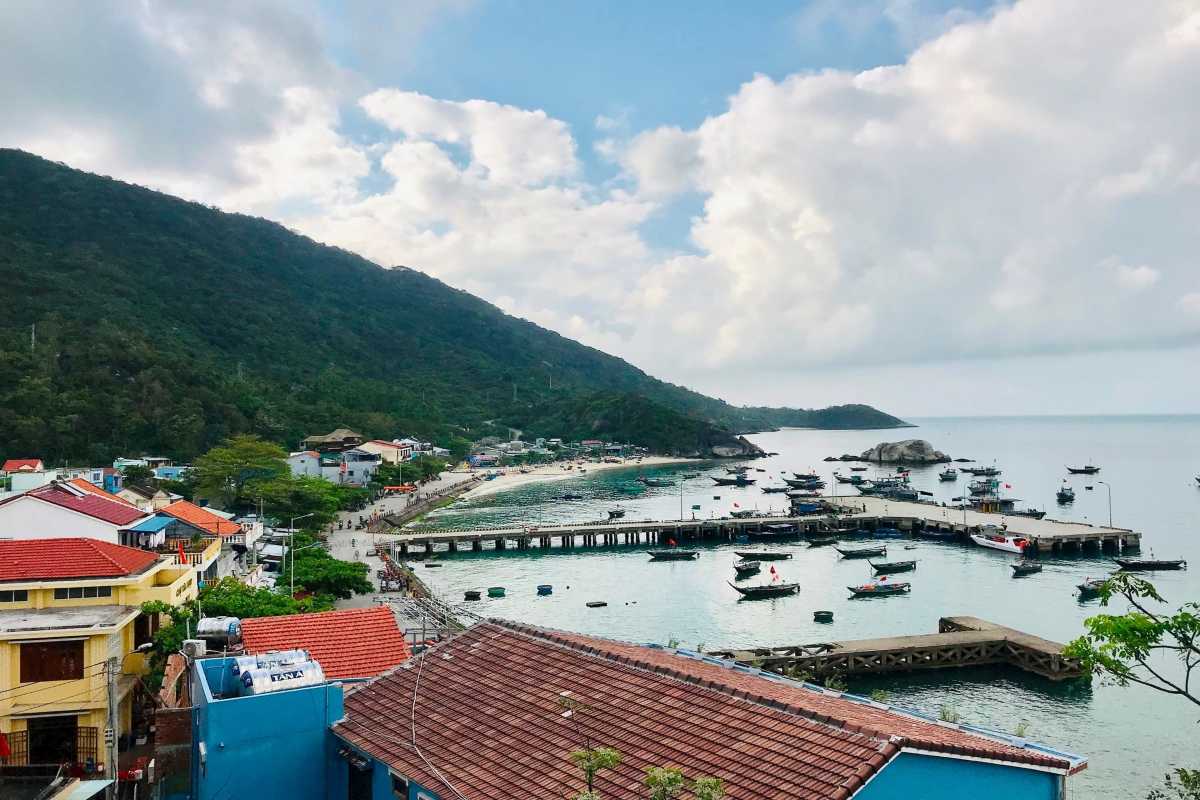 Cham Islands Fishing Village and Harbor Overview Aerial view of a fishing village and busy harbor at Cham Islands surrounded by green hills