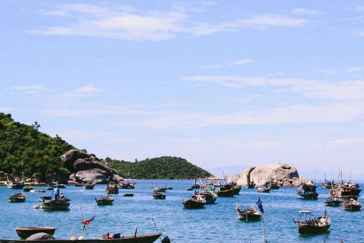 Rocky Shoreline and Clear Waters at Cham Islands Rocky coast with crystal-clear blue waters at Cham Islands beach under blue sky