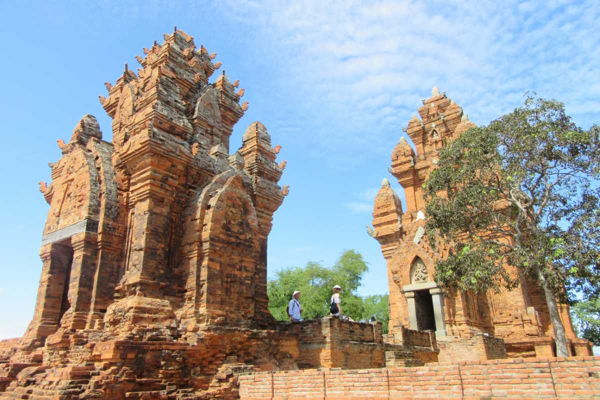 Cham Tower Ruins Phan Rang Thap Cham Ninh Thuan Visitors exploring Cham Tower ruins at Po Klong Garai site in Phan Rang Thap Cham with clear blue sky