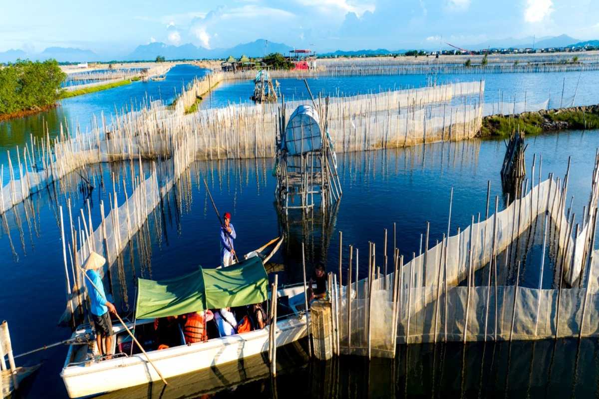 Children Playing on a Traditional Boat in Tam Giang Lagoon Children jumping off a traditional fishing boat into the waters of Tam Giang Lagoon at sunset