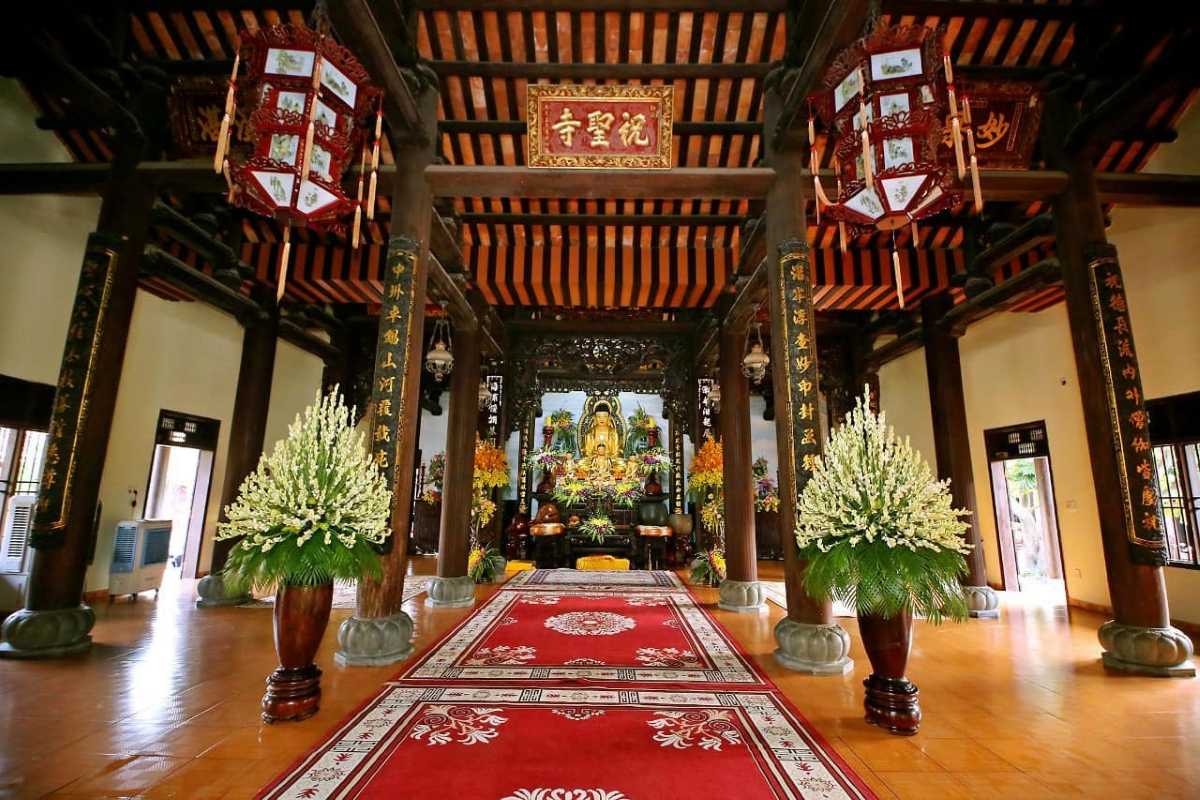 Outdoor Courtyard with Pathway and Lanterns at Chuc Thanh Pagoda Outdoor courtyard with stone pathway, lanterns, and tropical plants at Chuc Thanh Pagoda in Hoi An