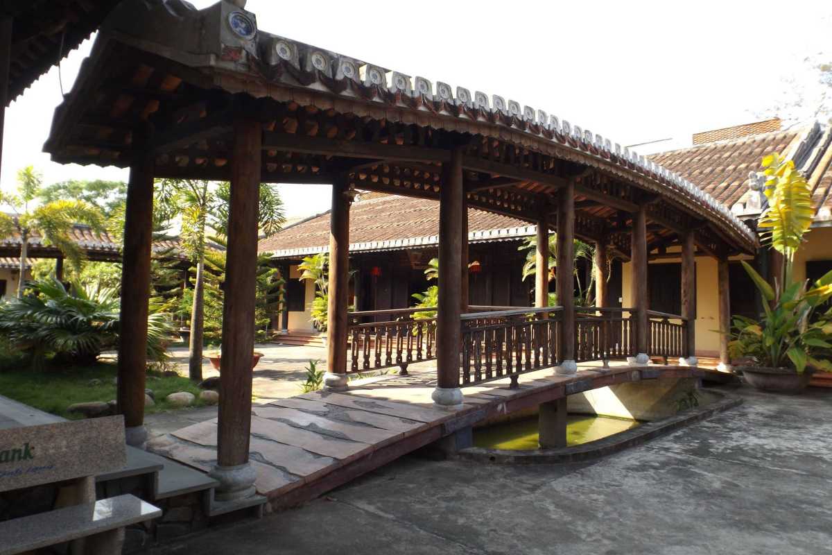 Traditional Wooden Bridge Inside Chuc Thanh Pagoda Covered wooden bridge over a small pond inside the peaceful grounds of Chuc Thanh Pagoda, Hoi An