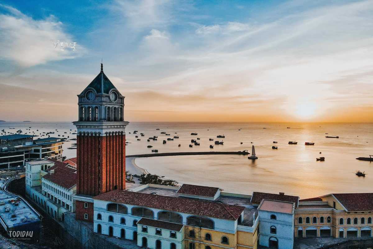 Clock Tower Phu Quoc and Coastal City View Wide shot of Clock Tower Phu Quoc with cityscape and coastal elements