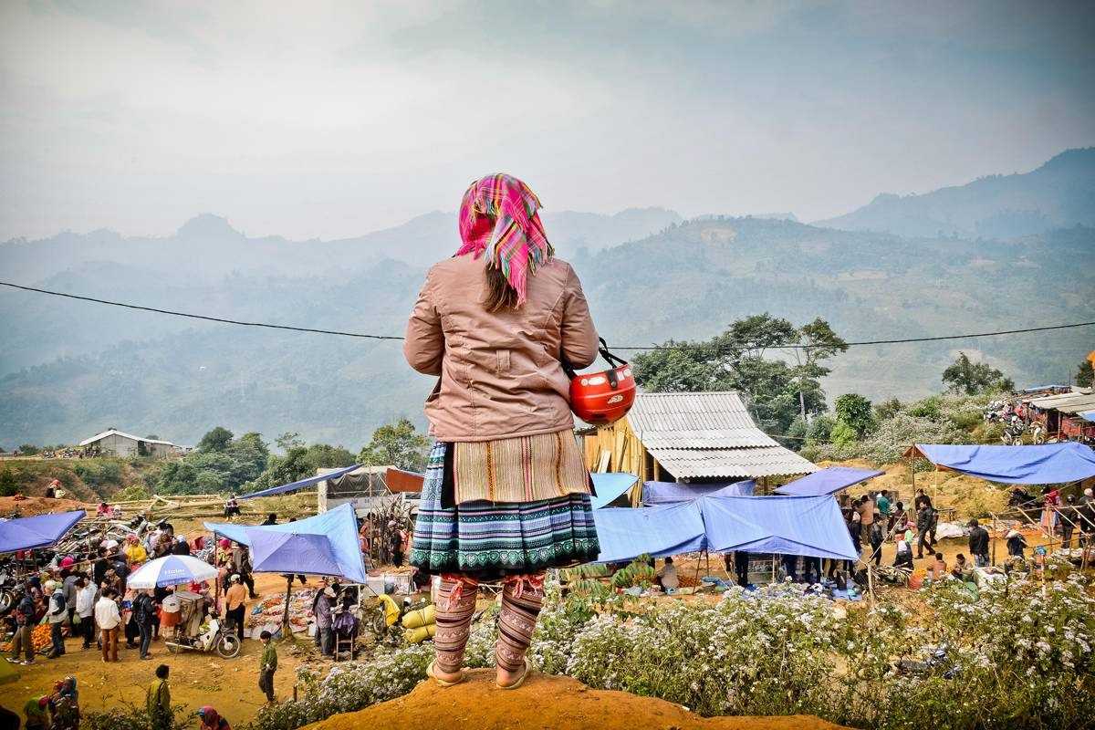 Coc Ly Market Sapa panoramic view scenic market Coc Ly Market Sapa panoramic view with a woman overlooking the colorful market tents and majestic mountain landscape.