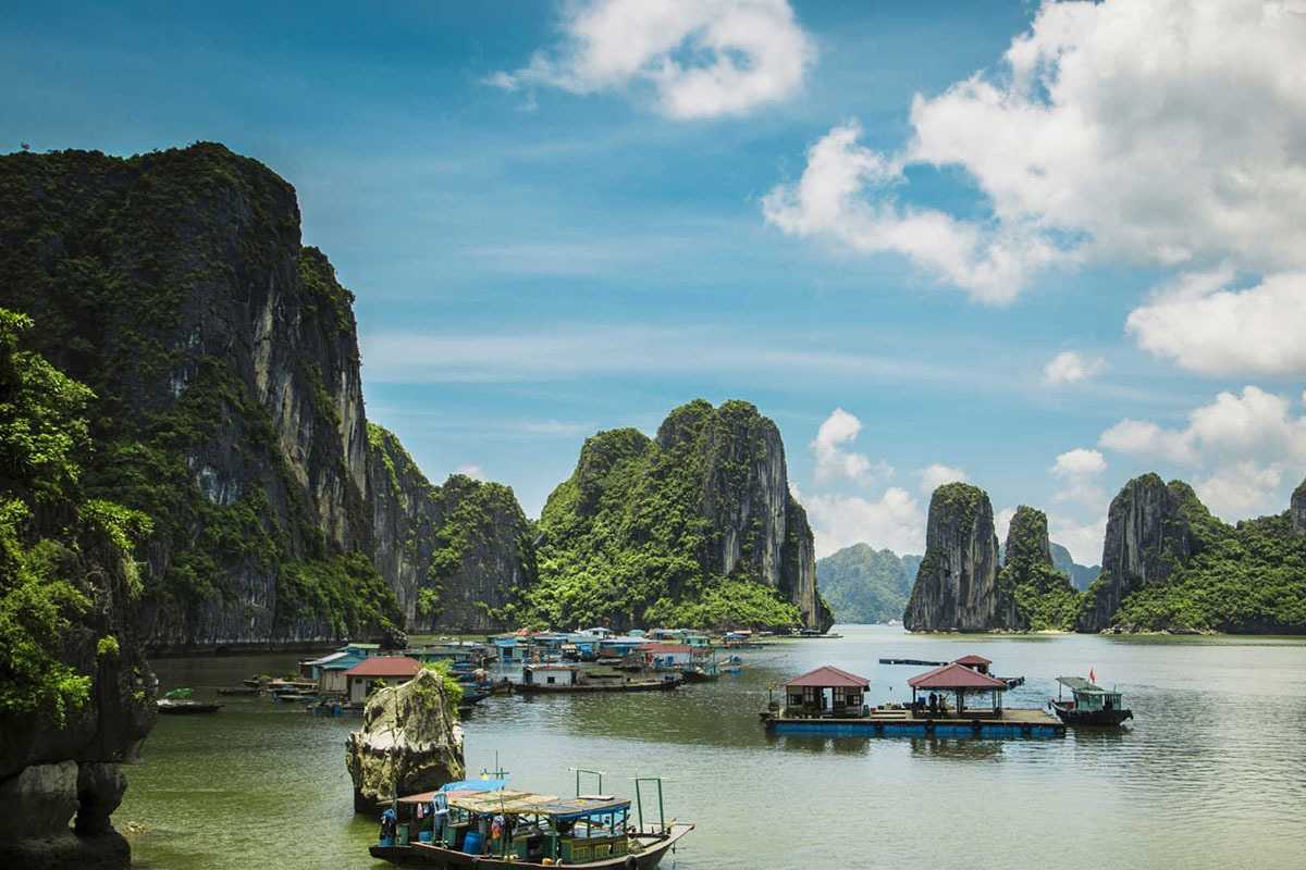 Cong Do Island Bai Tu Long Bay cruise ship in calm bay Cruise ship navigating calm emerald waters in Cong Do Island Bai Tu Long Bay, surrounded by limestone karsts.