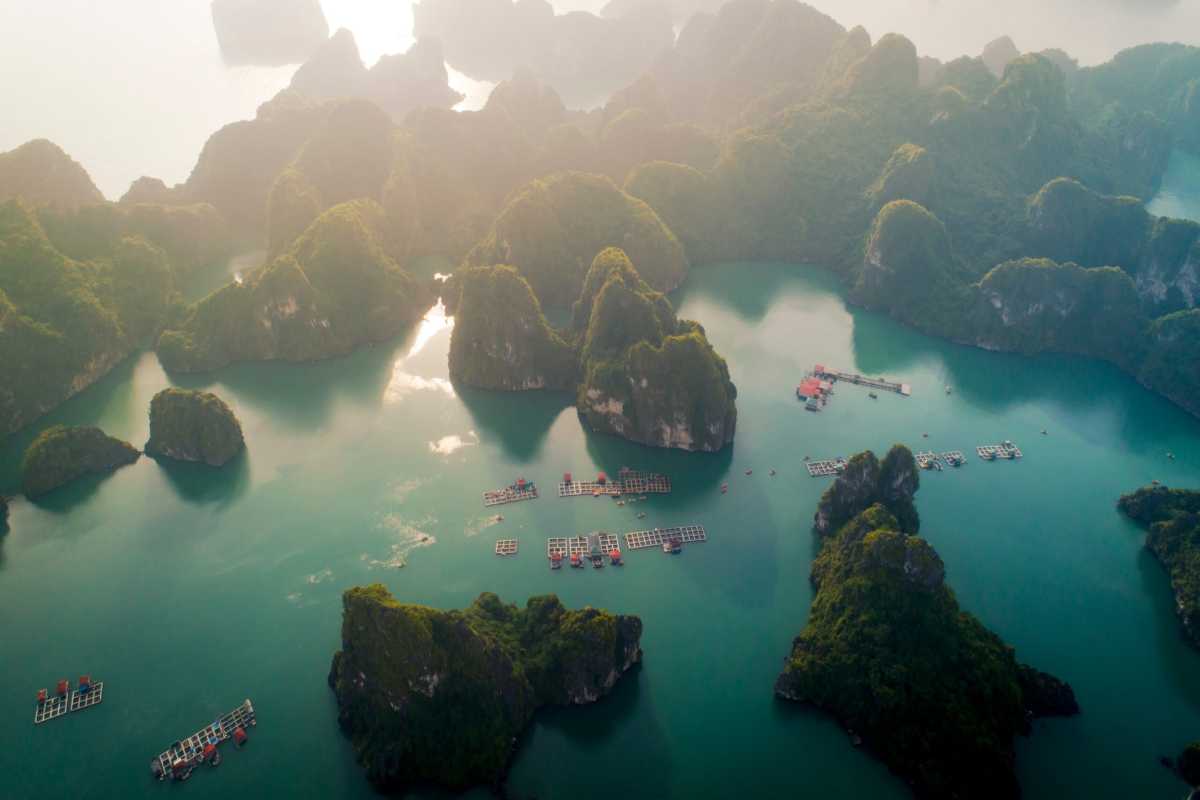 Cong Do Island Bai Tu Long Bay floating fish farms in tranquil bay Floating fish farms in the tranquil bay of Cong Do Island Bai Tu Long Bay, surrounded by green limestone hills.