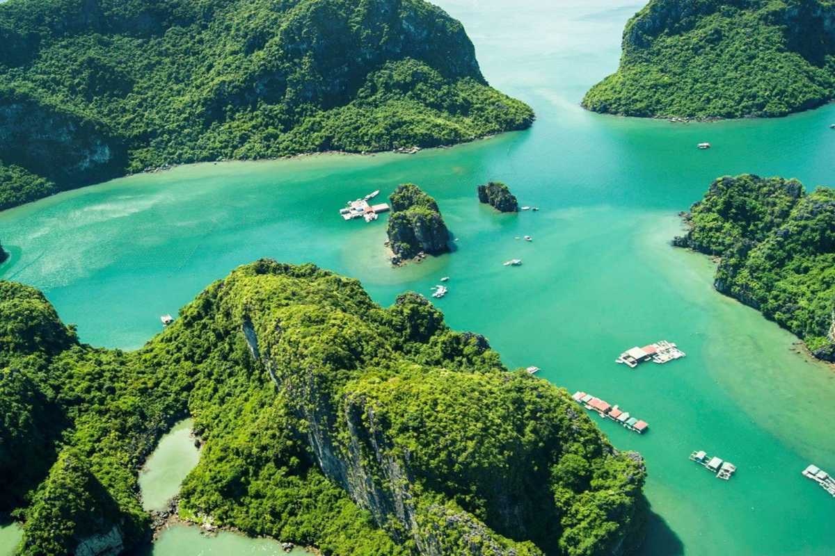 Cong Do Island Bai Tu Long Bay scenic bay with karst formations Scenic bay at Cong Do Island Bai Tu Long Bay with lush karst formations and floating houses on calm waters.