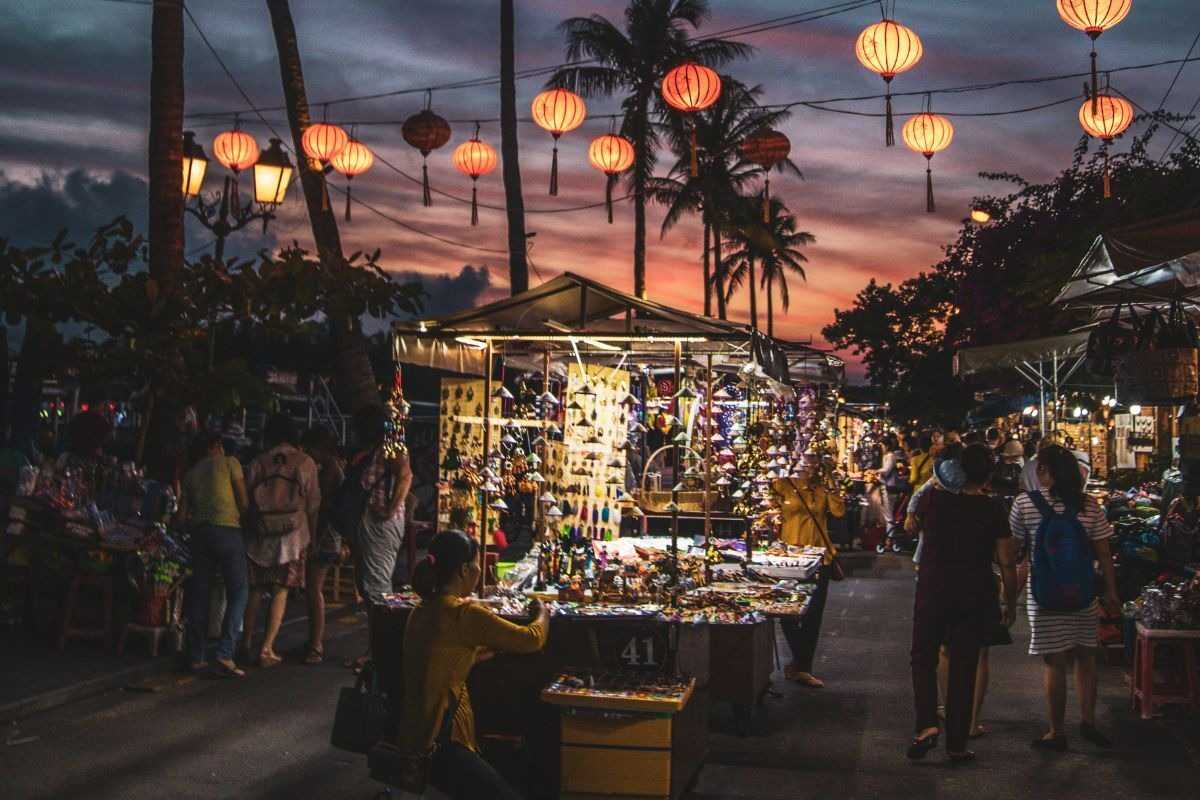 Crowded Night Market Street with Lantern Decorations Busy crowd walking under strings of lanterns in the lively Hoi An Night Market at night