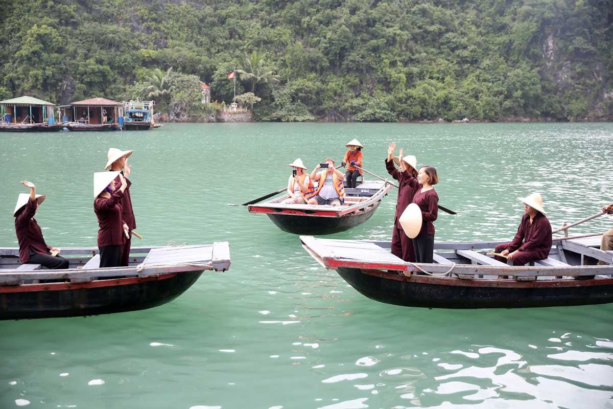 Floating houses and boats at Cua Van Floating Village Halong Bay Colorful floating houses and boats nestled against towering limestone cliffs at Cua Van Floating Village Halong Bay