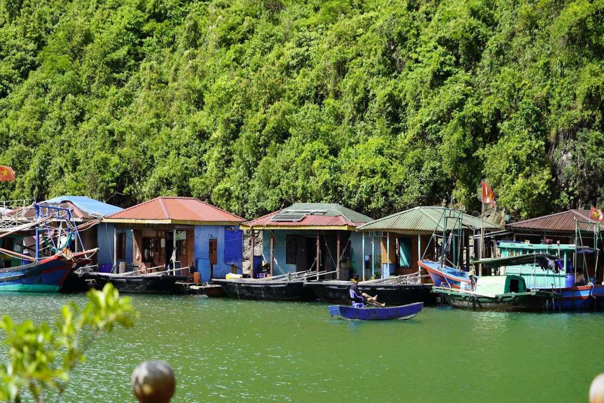 Floating village houses among limestone cliffs at Cua Van Floating village houses situated along limestone cliffs in Cua Van Floating Village Halong Bay, Vietnam
