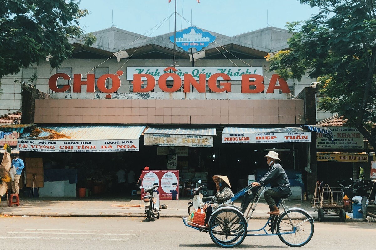 Cyclo passing by the entrance of Dong Ba Market in Hue