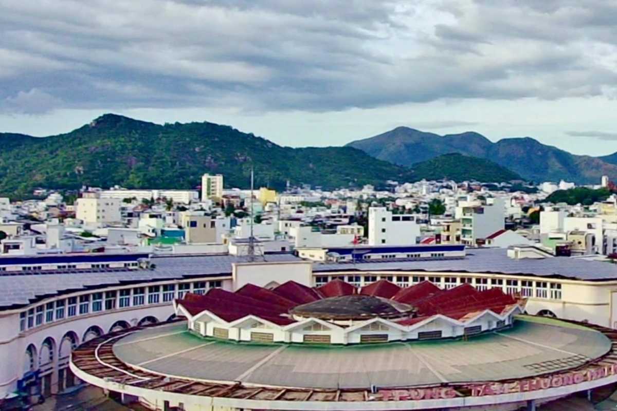 Dam Market Nha Trang circular rooftop and city skyline view View of Dam Market Nha Trang's circular roof with city buildings and mountains in the background