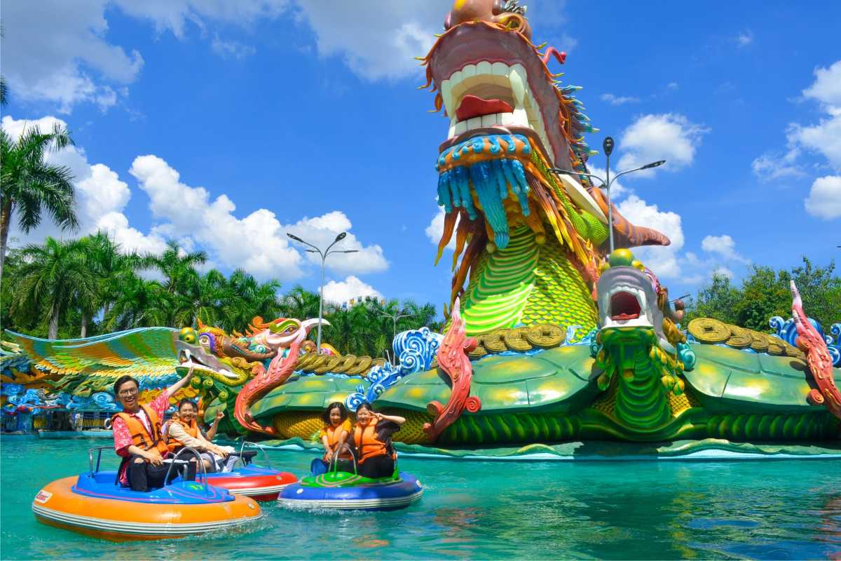 Pedal Boats on Lake with Large Dragon Statue Visitors riding pedal boats on the lake near a large colorful dragon statue at Dam Sen Water Park