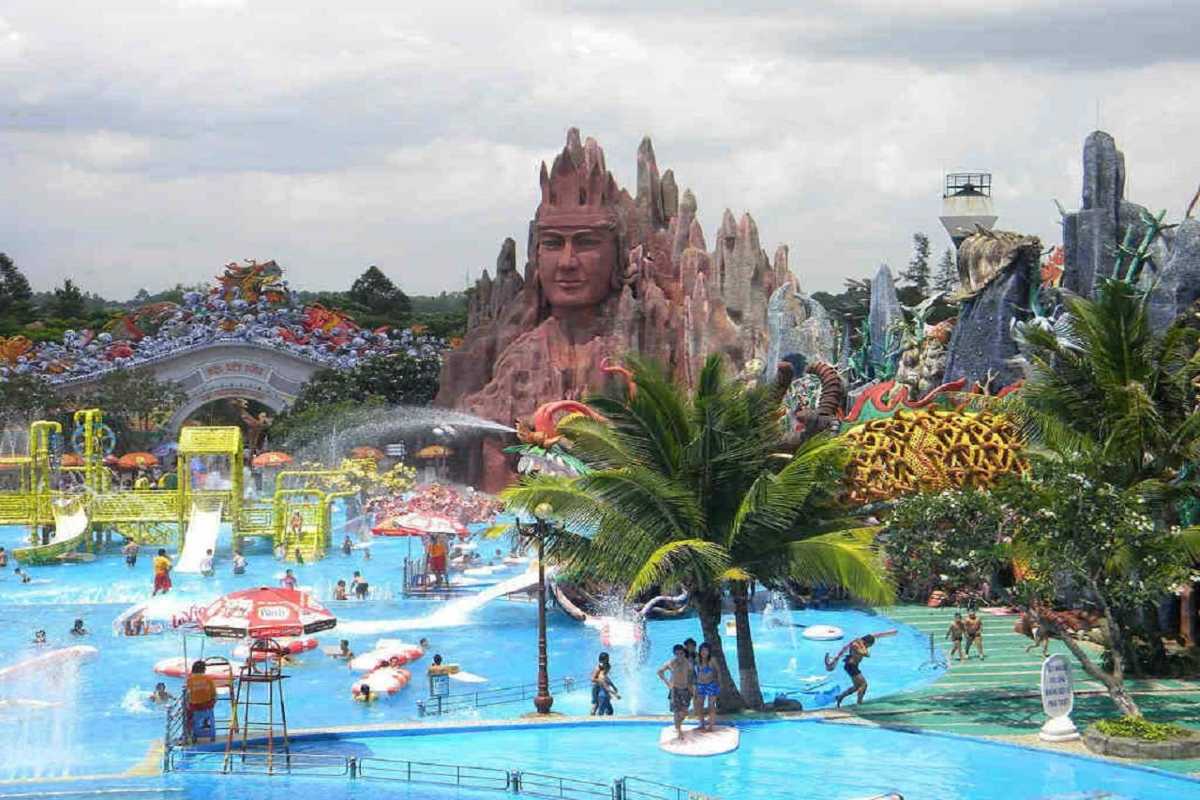 Entrance Gate and Water Attractions at Dam Sen Entrance area with water slides and colorful decorations under a partly cloudy sky at Dam Sen Water Park
