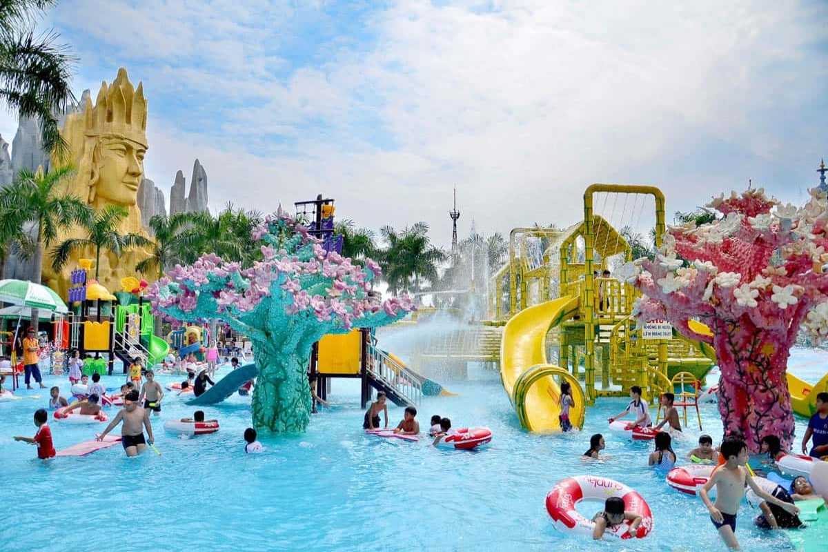Busy Kids’ Water Play Area with Slides and Sprays Children playing in the lively water playground with colorful slides and sprays at Dam Sen Water Park