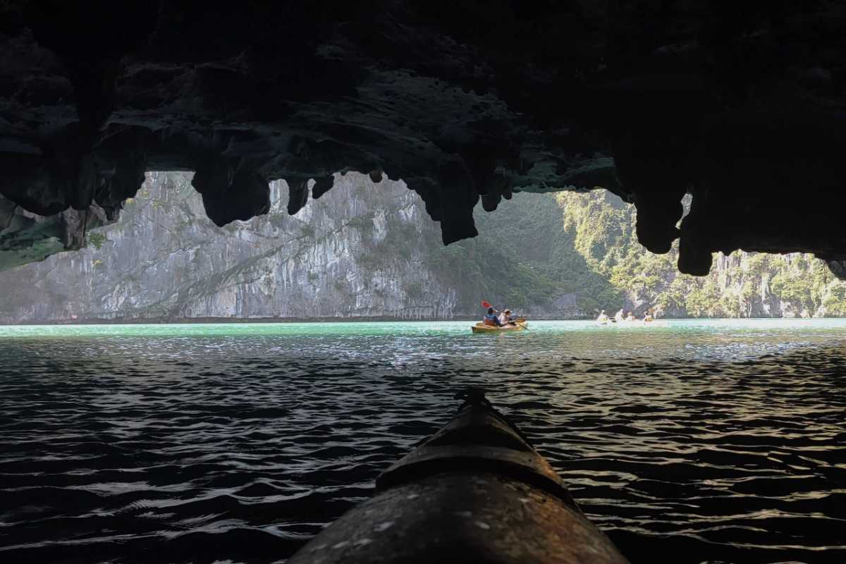 Dark and Bright Cave Halong Bay kayak view toward lagoon The view from a kayak inside Dark and Bright Cave Halong Bay shows the bright, turquoise lagoon and limestone cliffs.