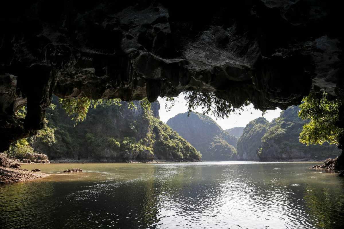 Dark and Bright Cave Halong Bay lagoon panorama Panoramic view of limestone mountains and lush greenery seen from within Dark and Bright Cave Halong Bay