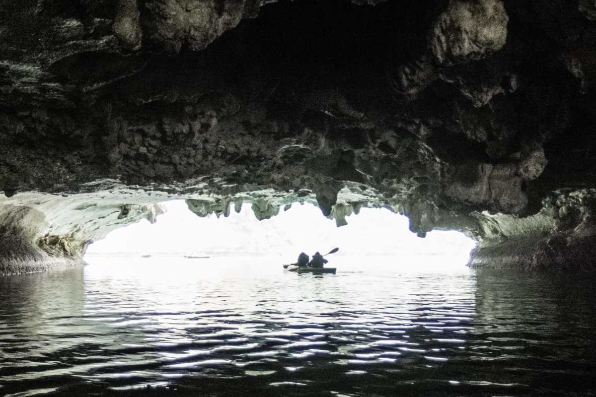 Dark and Bright Cave Halong Bay silhouette kayaking exit Silhouette of kayakers paddling out of Dark and Bright Cave Halong Bay, bright daylight ahead